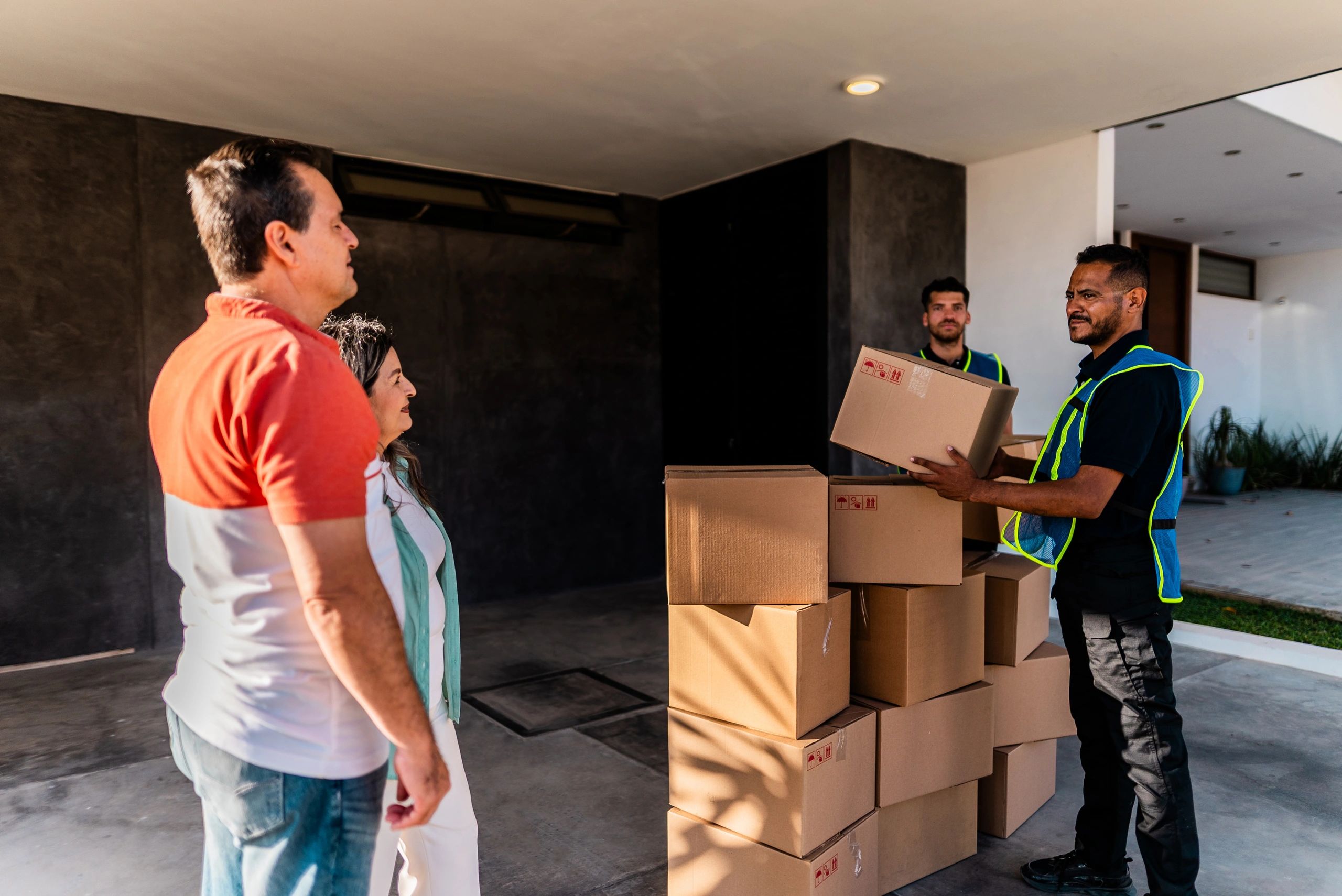 Equipo profesional de mudanza descargando pertenencias con atención al cliente